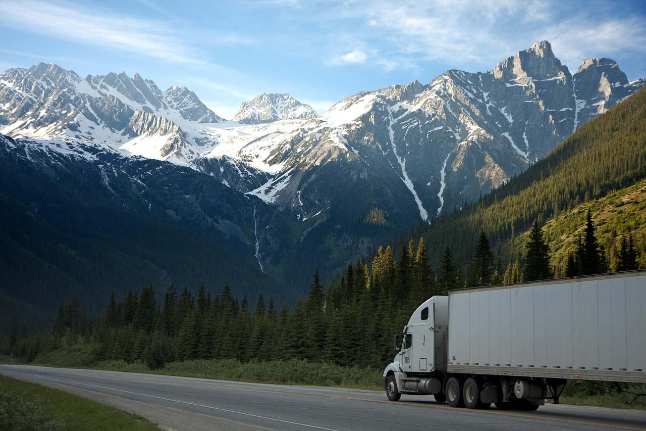 Truck on road with rocky mountains in background